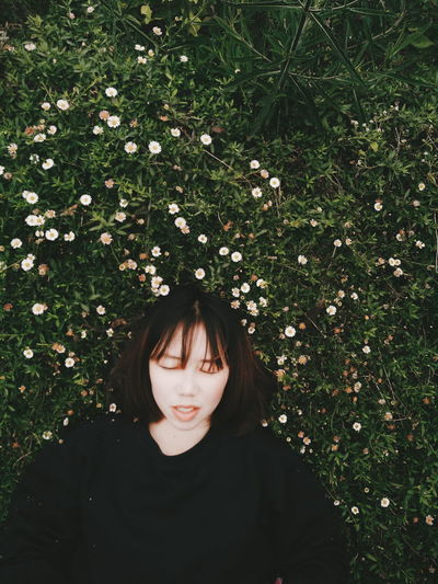 Directly above view of young woman lying on grass