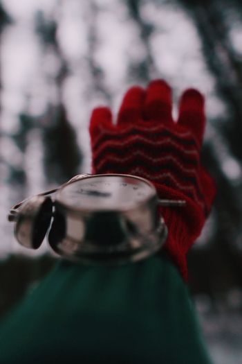 Close-up of human hand with alarm clock in winter
