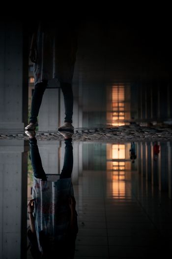 Reflection of man and woman standing in water