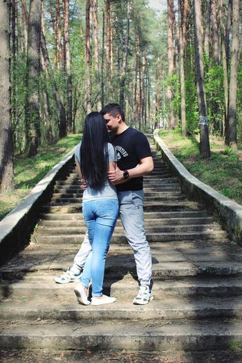 Full length of young couple kissing in forest