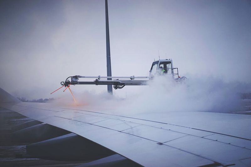 De-icing of airplane against cloudy sky