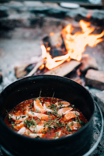 High angle view of food in container by campfire