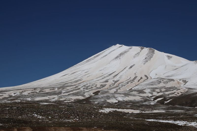 Snowcapped mountains against clear blue sky