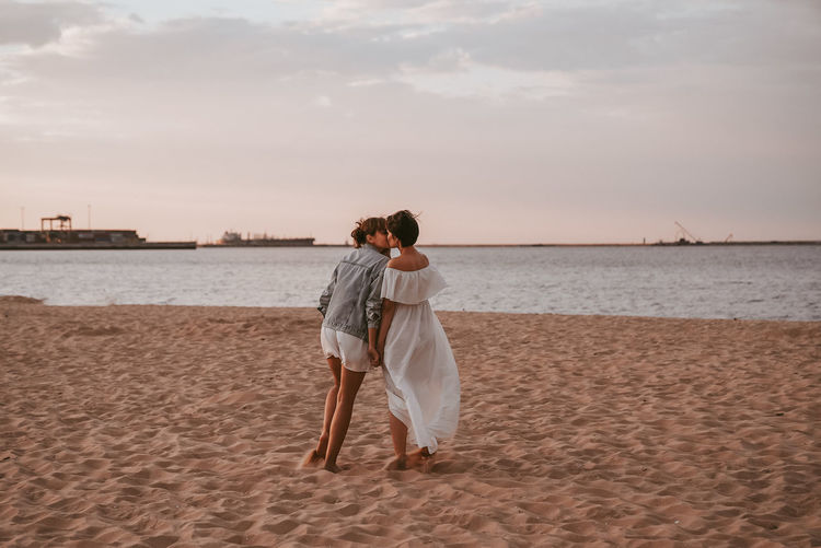 REAR VIEW OF WOMAN ON BEACH