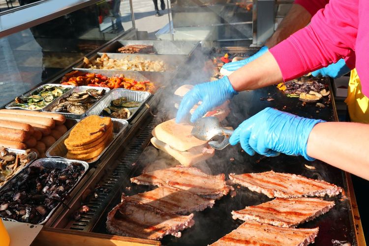 Chef with gloves and cooked sausages