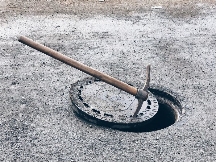 High angle view of pickaxe on manhole