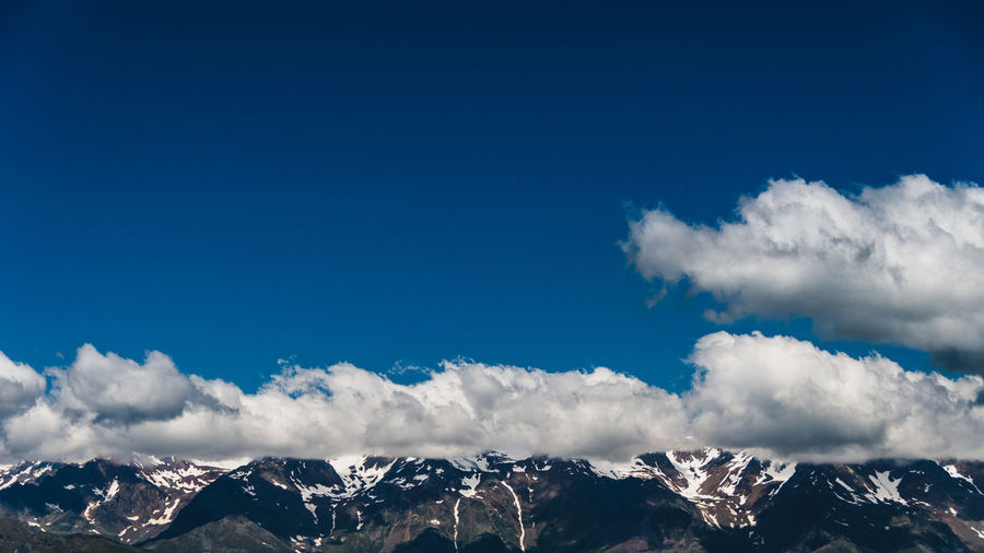 Scenic view of snowcapped mountains against blue sky