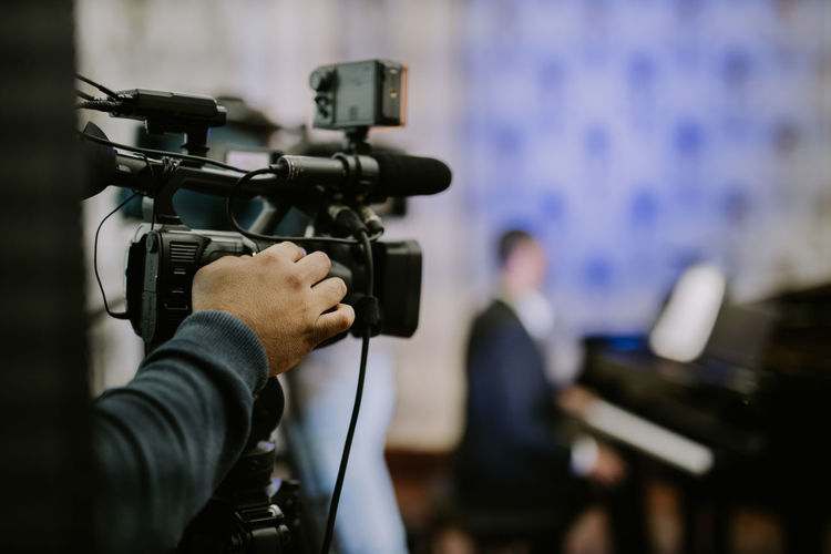 Midsection of man filming for tv