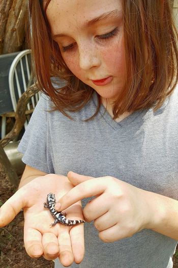 Close-up of girl holding lizard