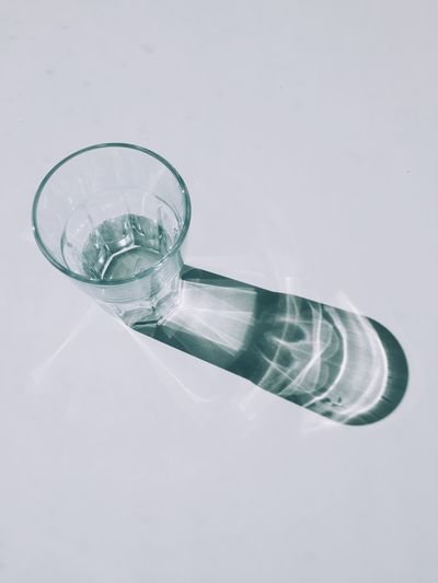 Glass of water on table against white background