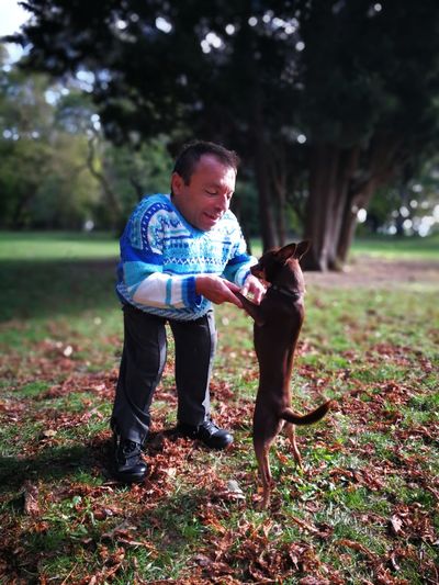 Dwarf man playing with dog at park