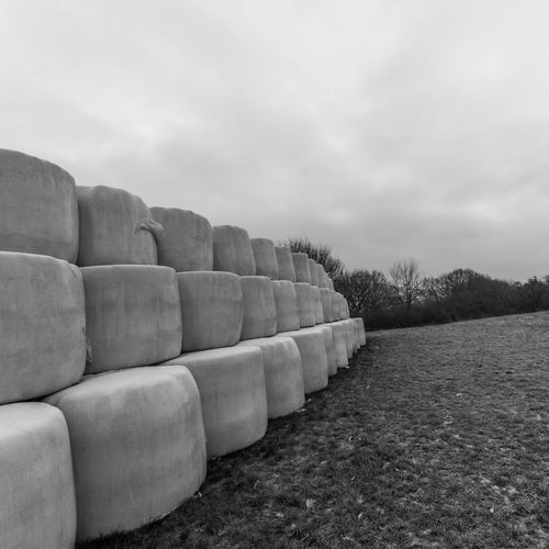 Stack of stones on field against sky