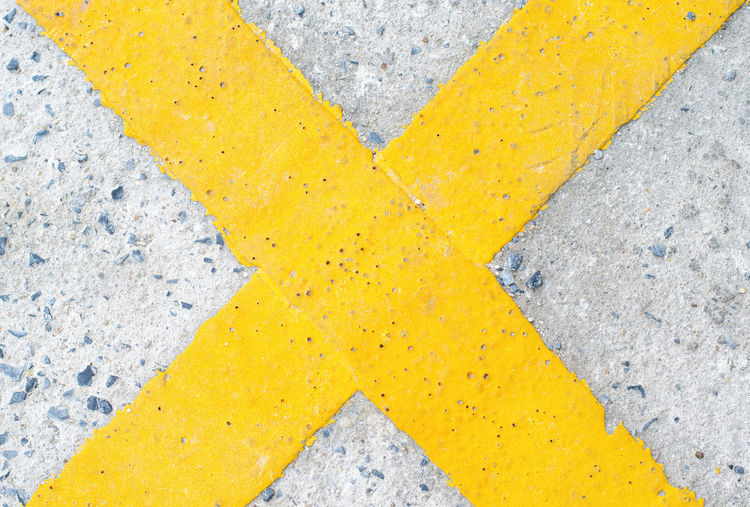 High angle view of yellow arrow symbol on street