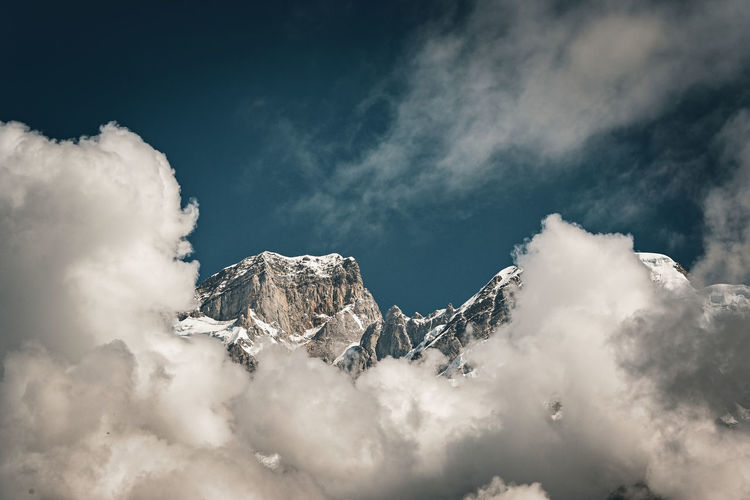 Low angle view of snowcapped mountains against sky