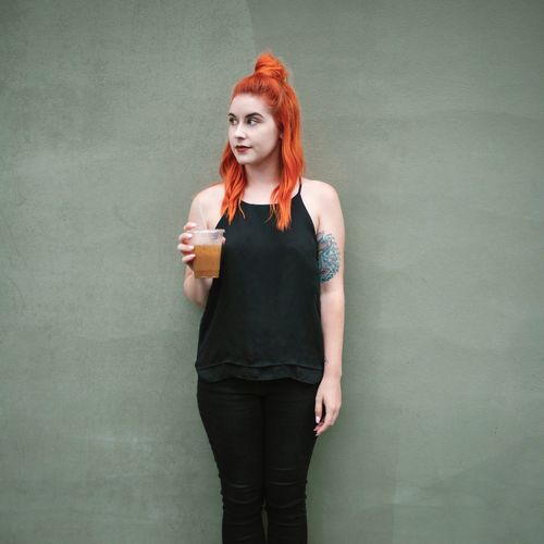 Portrait of redhead young woman with iced coffee