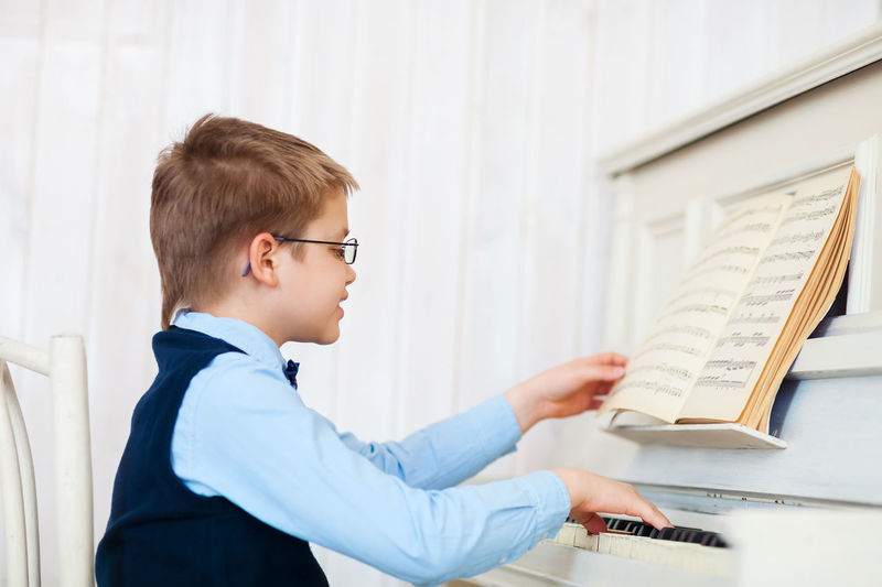Boy learning piano at home