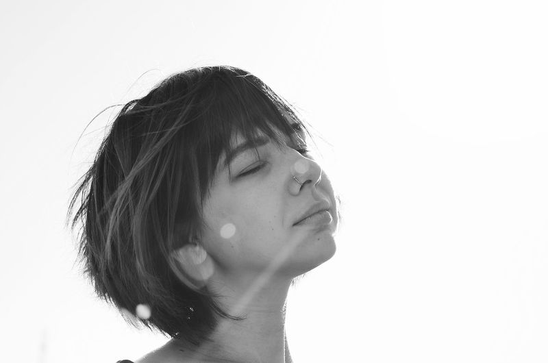 Woman with closed eyes against white background