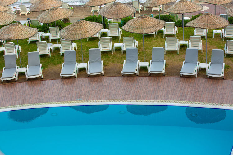 High angle view of lounge chairs by swimming pool