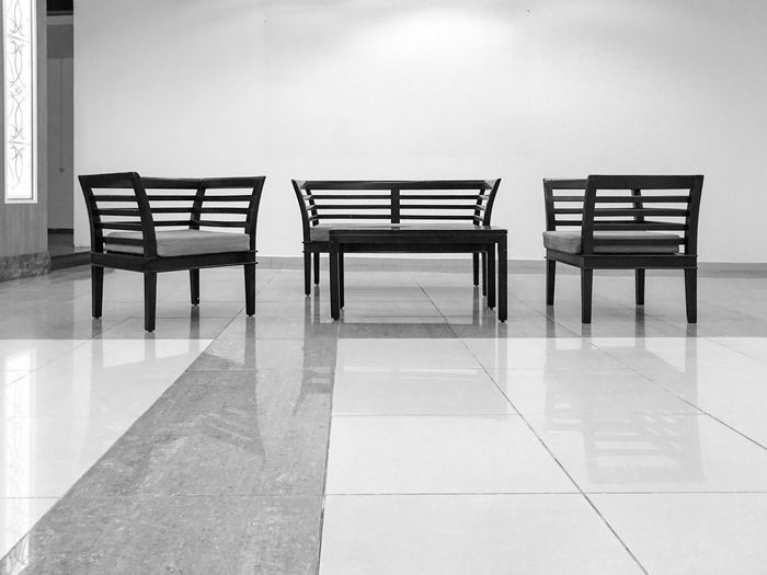 Empty chairs on floor against wall in hotel lobby