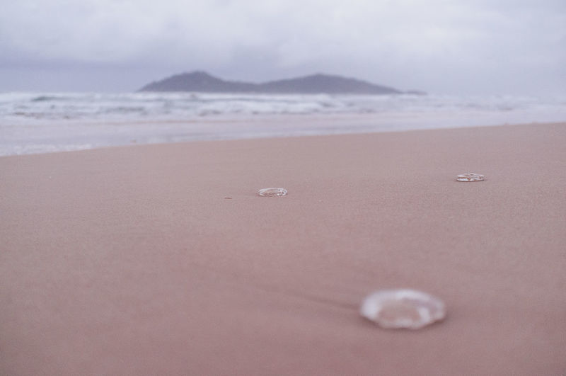 Surface level of sandy beach against sky