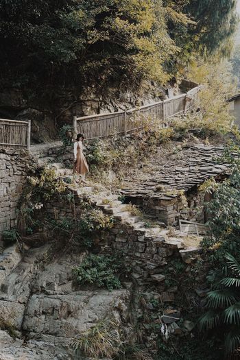 Woman walking on staircase in forest