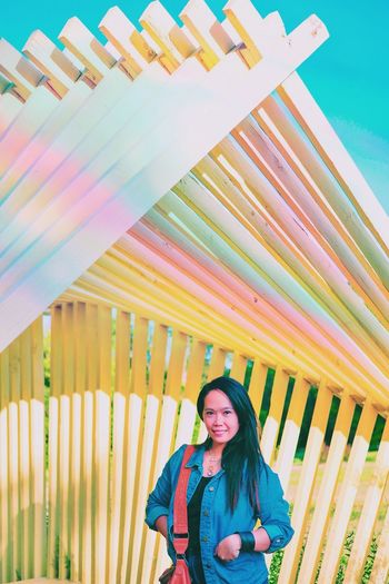 Portrait of smiling woman below built structure
