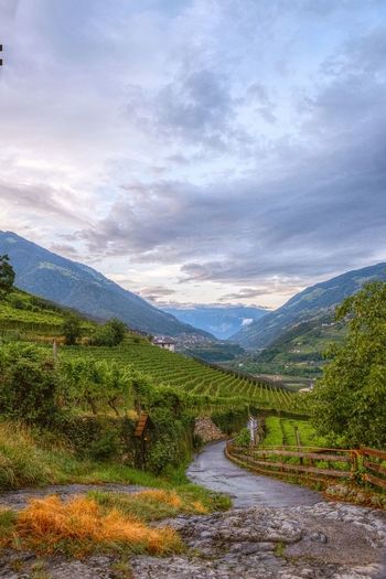 Scenic view of stream amidst mountains against sky