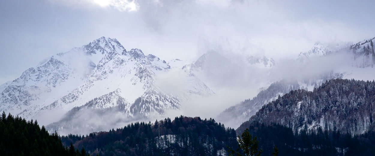 Panoramic view of mountains against sky during winter