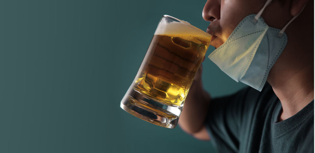 Midsection of man holding beer glass