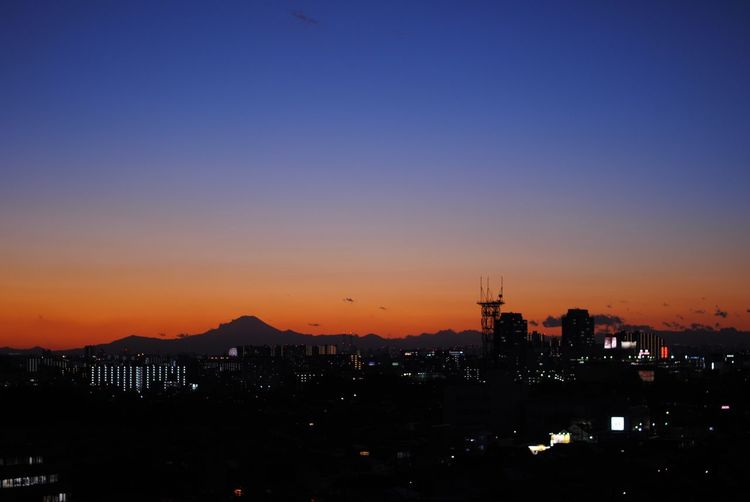 High angle view of silhouette buildings against sky during sunset