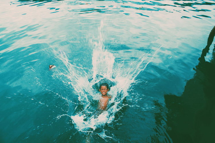 High angle view of boy splashing water in lake