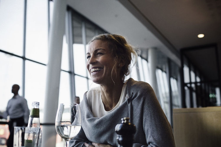Happy businesswoman sitting at cafe in airport