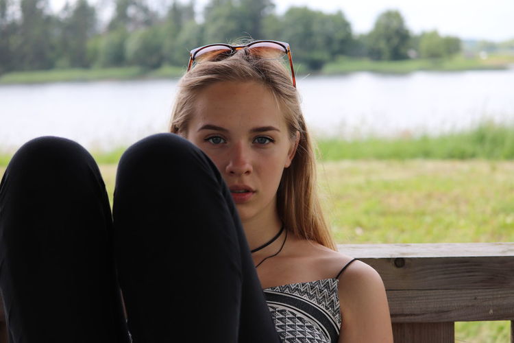 Portrait of woman sitting against lake