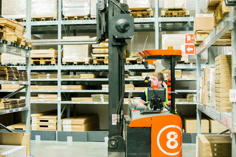 Worker driving forklift in factory