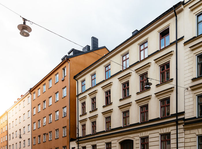 Low angle view of old residential buildings in sofo district in stockholm. sun flares