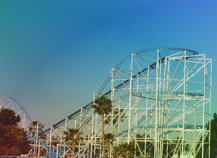 Low angle view of roller coaster against blue sky