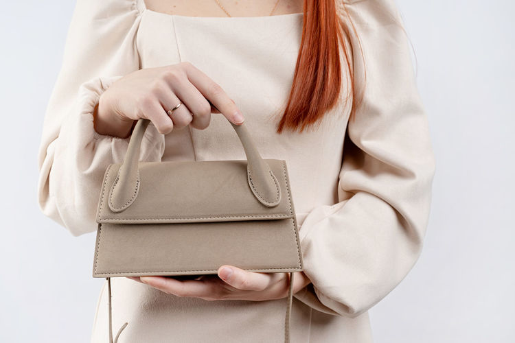 Midsection of woman holding box against white background