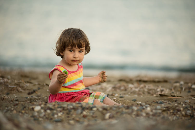 Portrait of cute girl sitting on beach