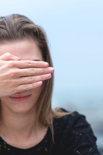 Woman covering eyes with hands