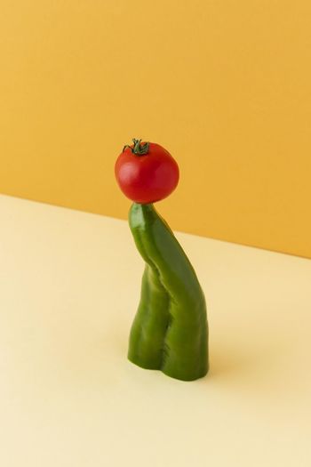 Bell pepper and cherry tomato against yellow background