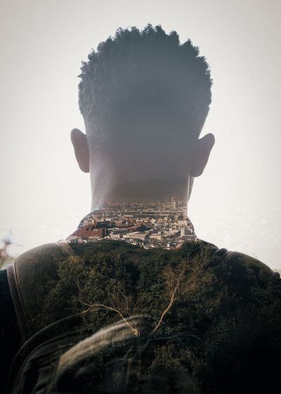 Double exposure of man and landscape against sky