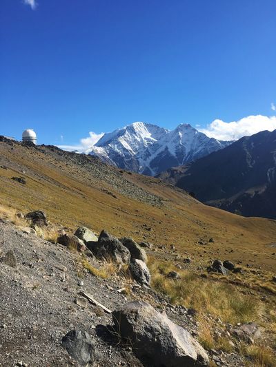 Scenic view of snowcapped mountains against clear blue sky