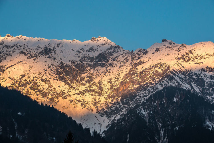 Low angle view of mountains against clear blue sky