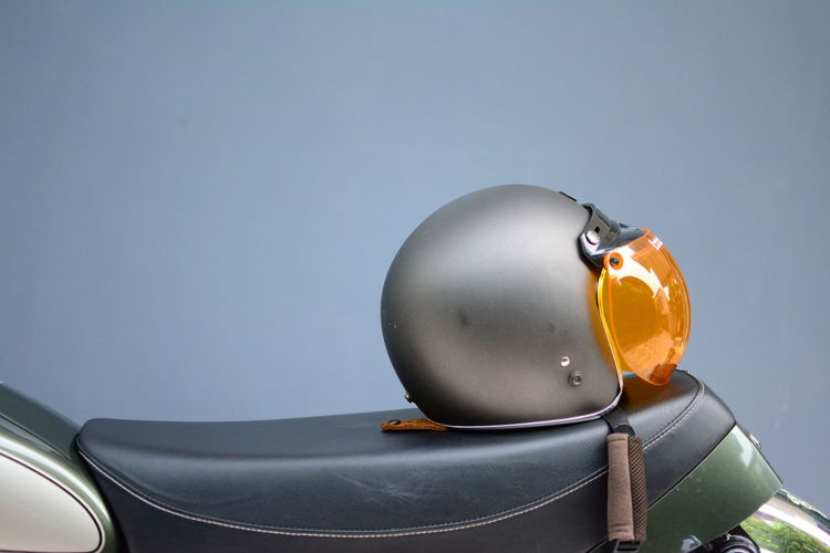 Close-up of scooter and helmet against gray background