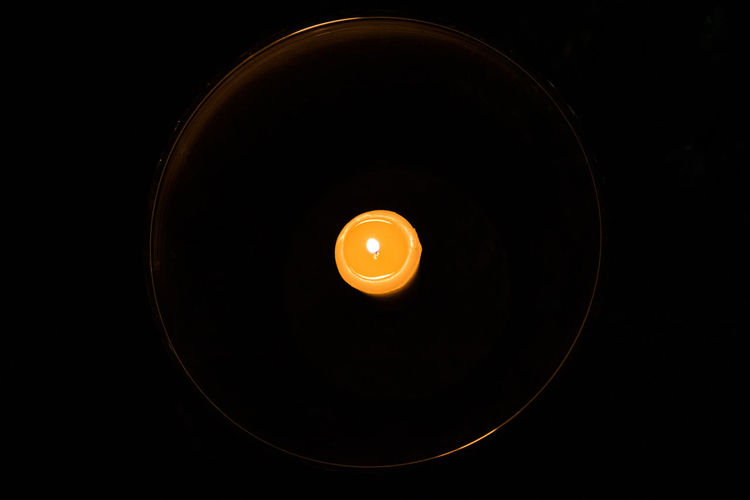 Directly above shot of illuminated electric lamp against black background