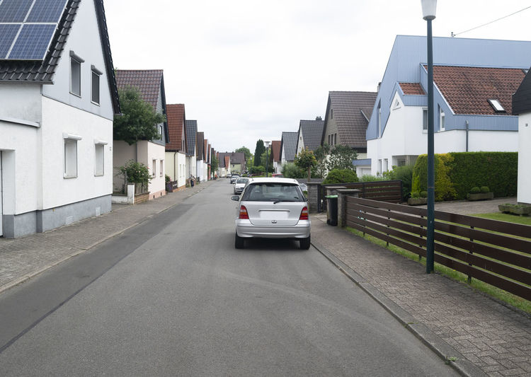 Cars on road amidst buildings against sky in city