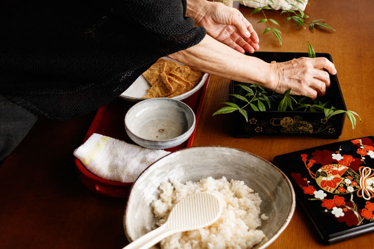 Midsection of woman preparing food on table.