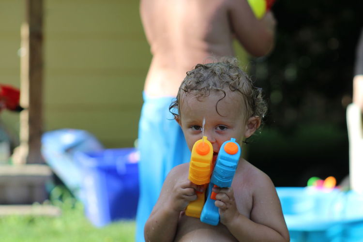 Portrait of boy holding squirt guns