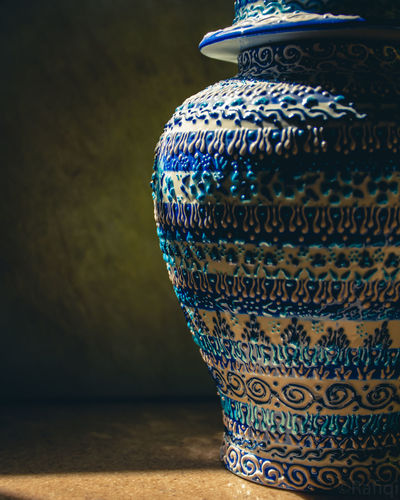 Close-up of vase on table against wall