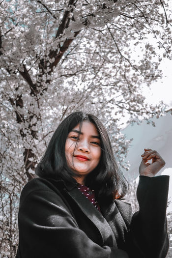 Portrait of smiling woman standing against plants